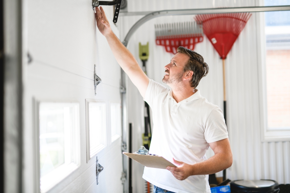 a man inspecting a garage door to see what the best replacement would be